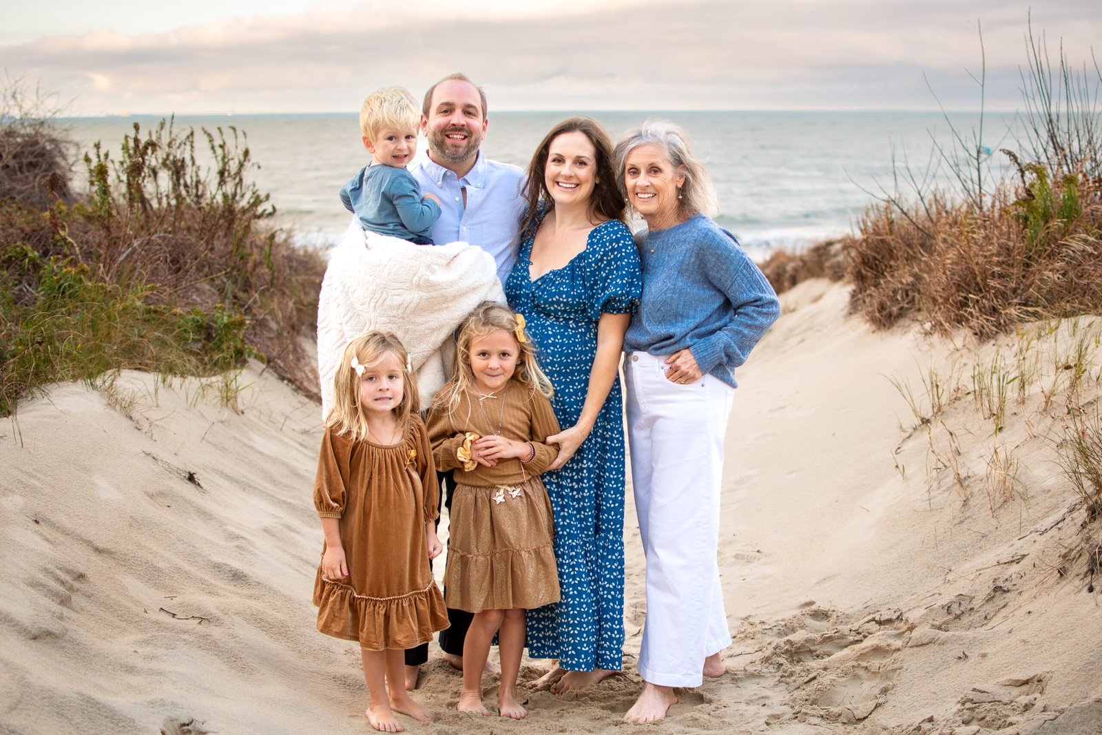 Family in soft neutral outfits at sunset in Virginia Beach